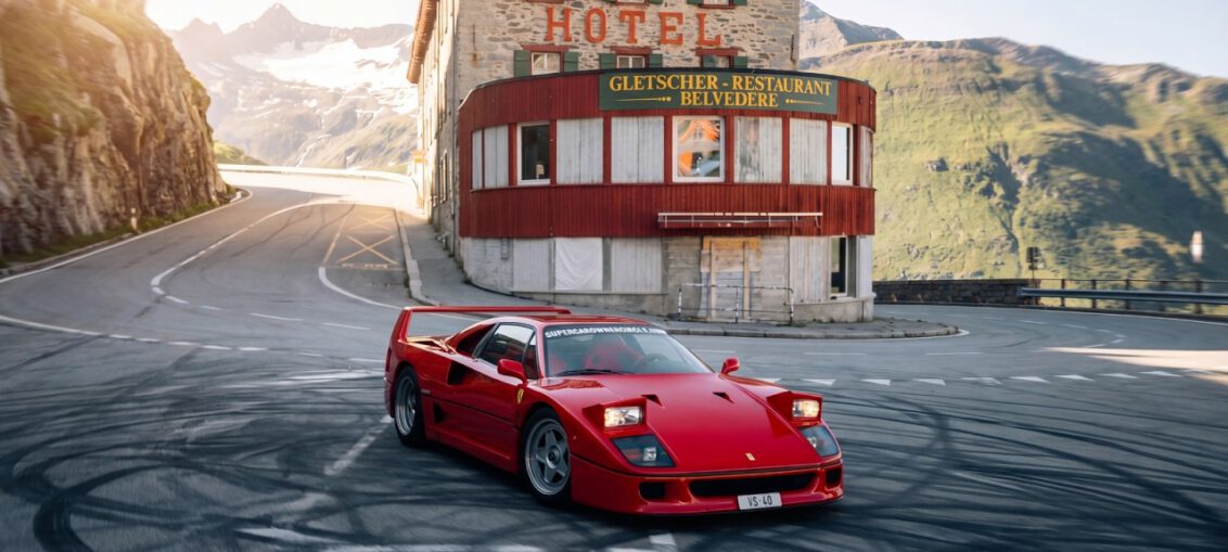 Ferrari F40 driving at high speed on closed mountain road in the Swiss Alps during exclusive supercar event