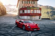 Ferrari F40 driving at high speed on closed mountain road in the Swiss Alps during exclusive supercar event