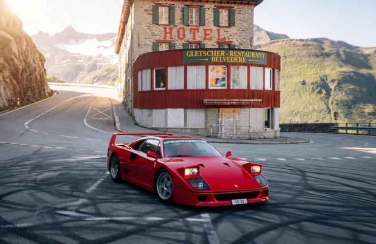 Ferrari F40 driving at high speed on closed mountain road in the Swiss Alps during exclusive supercar event