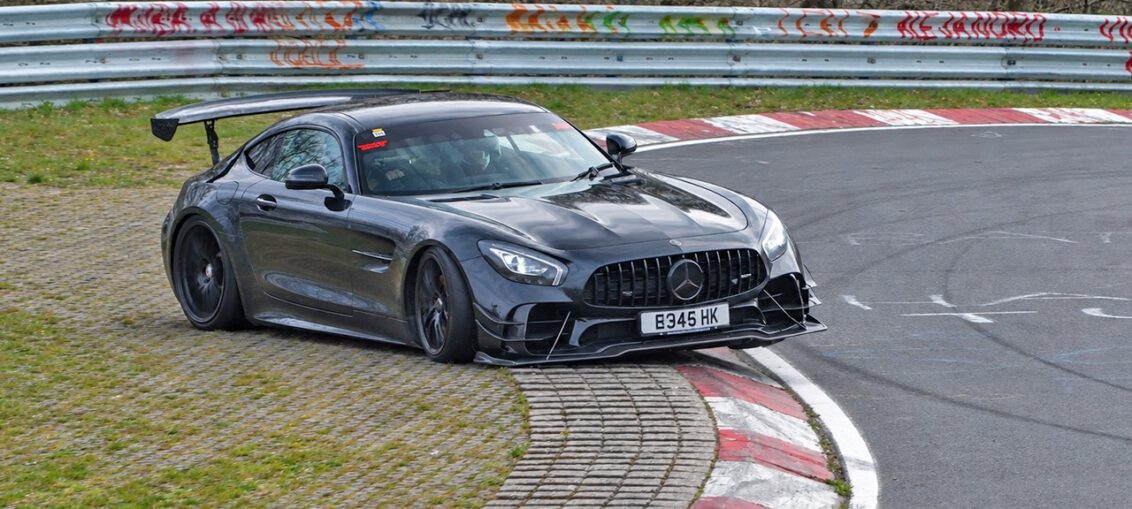 Car losing control at Adenauer Forst during a Nürburgring Nordschleife tourist drive, running wide onto the grass.